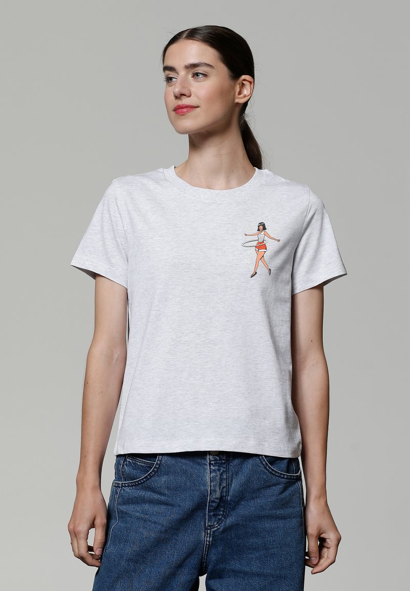 Graues Baumwoll-T-Shirt mit kurzen Ärmeln, mit einem farbenfrohen Hula-Tänzer-Design auf der linken Brust. Gerader Schnitt und lässige Passform.