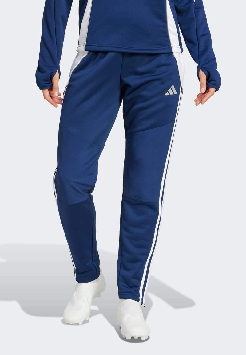 Marineblaue Sporthose mit weißen Seitenstreifen, aus glattem, dehnbarem Material. Mit Reißverschlussabschlüssen und einem Adidas-Logo auf dem Oberschenkel.