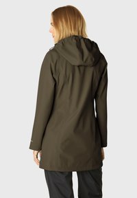 Chaqueta impermeable de color verde oliva con un diseño ajustado, capucha ajustable y textura suave. Presenta detalles de costura y mangas largas.