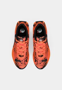 Sapatilhas atléticas laranja brilhante com detalhes em preto, parte superior em malha estampada, design com atacadores, apresentando amortecimento de ar e bico redondo.