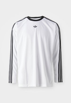 Chemise blanche à manches longues en tissu doux avec des accents noirs, présentant trois rayures noires le long des manches et un petit logo noir.
