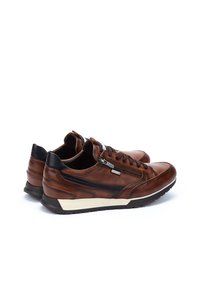 Sneakers in pelle marrone con accenti neri, punta arrotondata, design con lacci, zip laterale e suola intermedia bianca. Superficie texturizzata e finitura liscia.