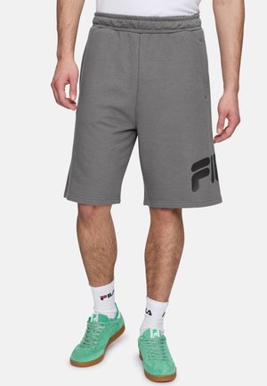 Shorts de algodón grises con cinturilla elástica y bolsillos laterales, con un gran logo negro en la pierna izquierda.