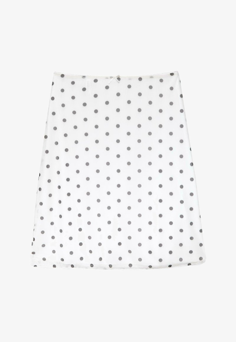 Jupe trapèze blanche avec des pois noirs uniformément espacés et un petit nœud à la taille.