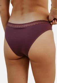 Culotte en coton bordeaux avec une bordure en dentelle à la taille, présentant une texture douce et une coupe classique vue de dos.