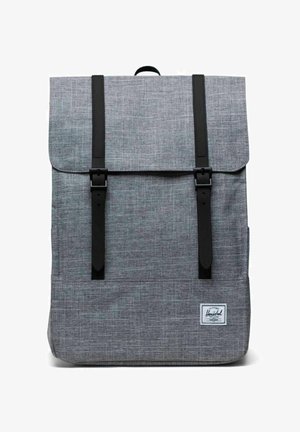 Sac à dos en tissu gris texturé avec des sangles à boucle noire et un petit patch blanc avec le logo Herschel dans le coin inférieur droit.