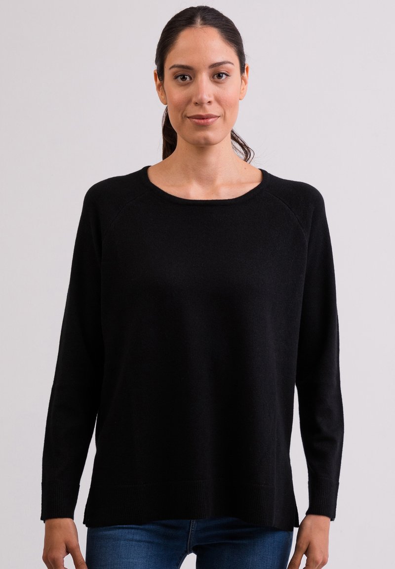 Schwarzer Pullover mit rundem Hals, langen Raglanärmeln, geripptem Saum und entspannter Passform. Weiche Textur, aus einem Strickmaterial gefertigt.