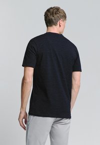 Marineblauw T-shirt met korte mouwen en dunne horizontale strepen. Zachte katoen stof, klassiek ronde halsontwerp en een relaxte pasvorm.