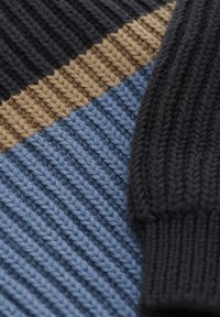 Strickstoff mit drei Streifen: dunkles Marineblau, Beige und Hellblau. Die Struktur ist gerippt mit einem glatten Finish an den Kanten.