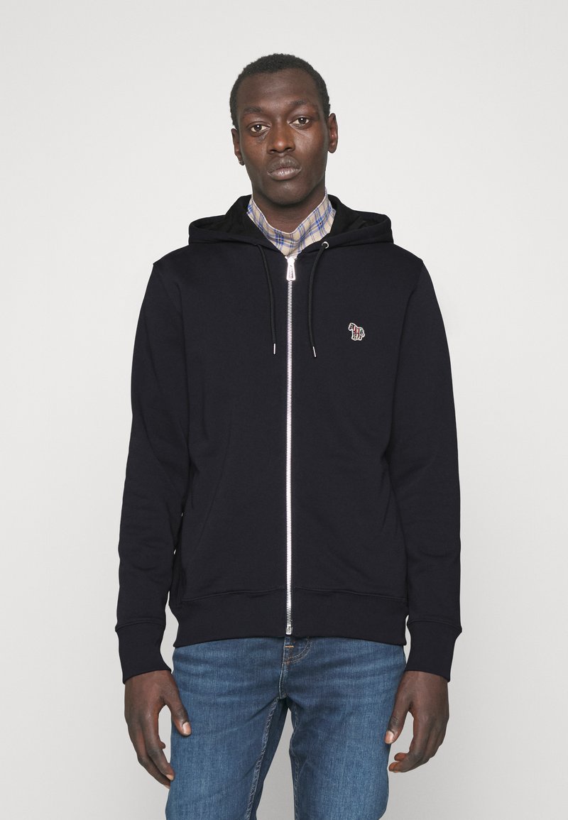 Mörkblå zip-up hoodie med dragsnören och kängurufickor, med en liten flerfärgad logotyp på vänster bröstområde. Klassisk passform.