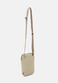 Borsa a tracolla in tessuto beige con chiusura a zip, forma slim, tracolla regolabile e dettagli di cucitura discreti.