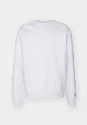 Light grey sweatshirt featuring a crew neckline, long sleeves, ribbed cuffs, and a small logo patch near the hem. Made of soft fabric.