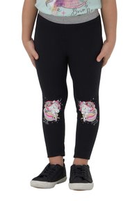 Leggings neri con una cintura accentuata in argento, con grafiche di unicorni sulle ginocchia. Abbinati a scarpe da ginnastica nere. Texture liscia.