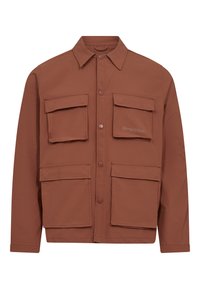 Chaqueta marrón de botonadura hecha de una tela ligera, con dos grandes bolsillos en el pecho y dos bolsillos inferiores, que presenta un collar puntiagudo y el logo de la marca.