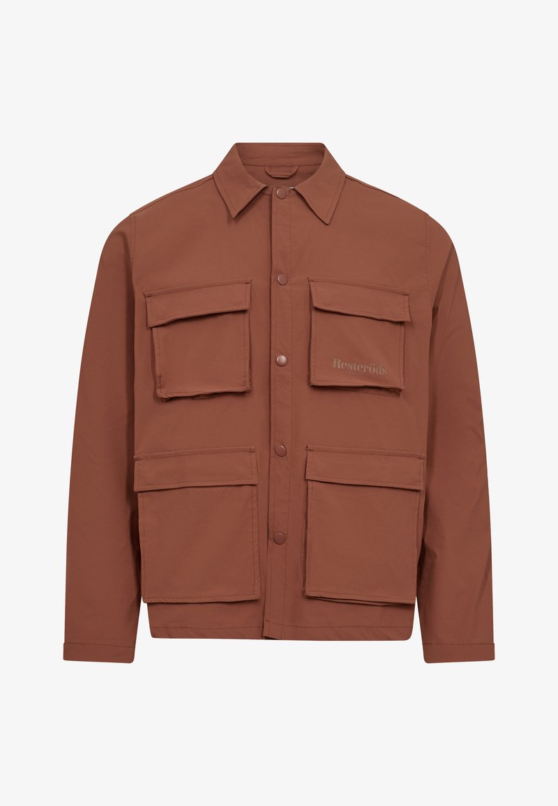 Chaqueta marrón de botonadura hecha de una tela ligera, con dos grandes bolsillos en el pecho y dos bolsillos inferiores, que presenta un collar puntiagudo y el logo de la marca.