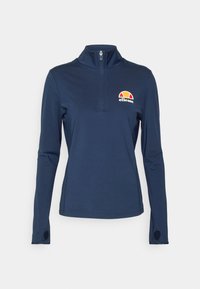 Mörkblå långärmad topp med halvdragkedja i kragen, som har en färgglad Ellesse-logotyp på bröstet och tumhål i ärmsluten. Slät yta.