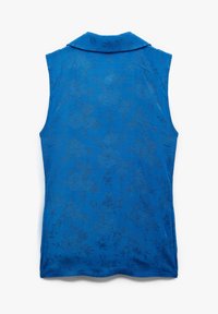 Ärmlös blå blus med en strukturerad blommönster, med krage och mjukt tyg. Designen är subtilt elegant och väldefinierad.