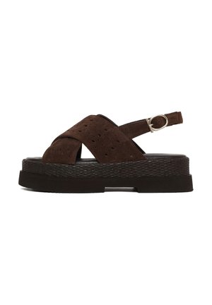 Sandalia de plataforma de ante marrón oscuro con correas cruzadas perforadas, correa ajustable en el tobillo y suela texturizada.