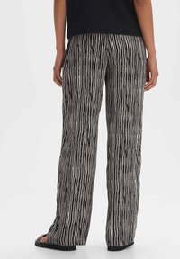 Zwart-wit gestreepte, brede broek met een relaxte pasvorm. Zachte stof met textuur, voorzien van verticale lijnen en een comfortabele tailleband.