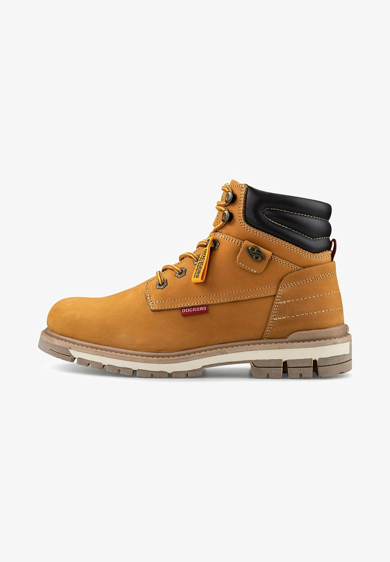 Tanfarbene Stiefel mit schwarzem gepolstertem Kragen, Metallösen und braunen Schnürsenkeln. Sie verfügen über eine robuste Gummisohle, eine kontrastierende weiße Zwischensohle und ein Logotag.