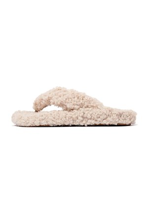 Beige fuzzy slippers with a textured surface, thong-style strap design, and a flat sole. The material appears soft and plush.