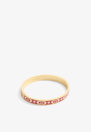 Bracelet en métal doré avec des accents en émail rouge, présentant un motif de logo répété et de petites pierres transparentes. Texture lisse, forme circulaire.