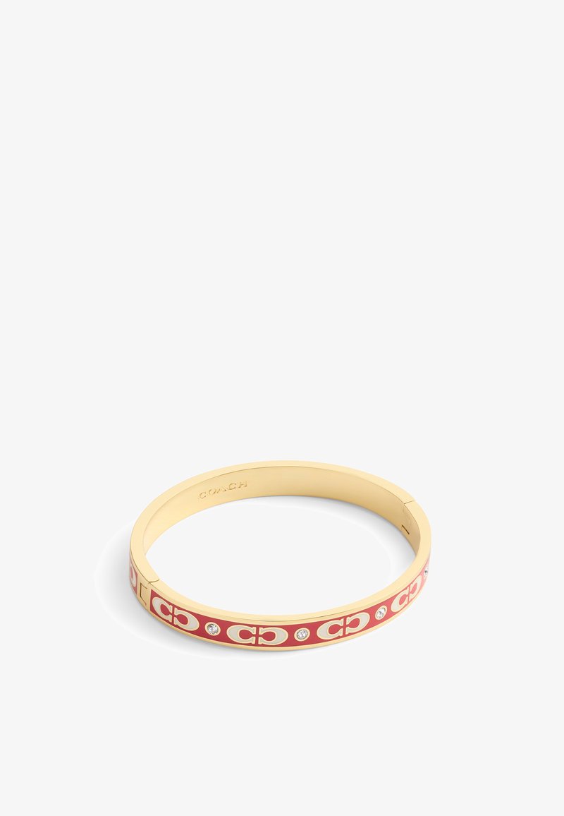 Bracelet en métal doré avec des accents en émail rouge, présentant un motif de logo répété et de petites pierres transparentes. Texture lisse, forme circulaire.