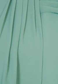 Tessuto blu chiaro con pieghe verticali e una trama morbida, caratterizzato da un design di piega ordinata e da una texture superficiale sottile e uniforme.