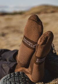 Bruna strumpor med ett ribbat mönster, förstärkt tå och häl, med ett kontrasterande band märkt "Danish Endurance" i vitt.