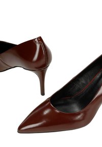 Hnědé kožené lodičky s špičatou špičkou a úzkým stiletto podpatkem, s černým vnitřním podšíváním a hladkým lesklým povrchem.
