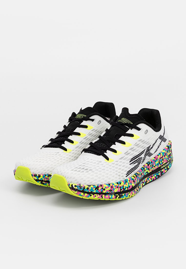 Des chaussures de course blanches avec des accents noirs, une tige en maille texturée, des lacets jaunes vifs et une semelle colorée mouchetée comportant des teintes de rose, de bleu et de vert.