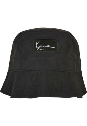 Black bucket hat made of textured fabric, featuring a wide brim and a rectangular logo patch with white lettering.