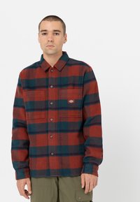 Rød og blå ternet flannel skjorte med knaplukning foran, to brystlommer og krave. Blød tekstur og afslappet pasform.