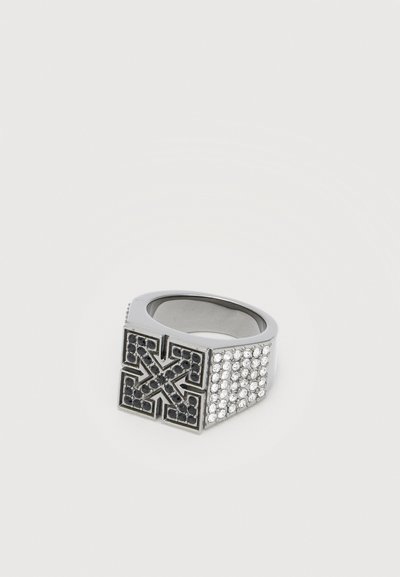 Bague en argent avec un dessus carré présentant un design de croix fléchée noire et des côtés ornés de multiples petits cristaux clairs.