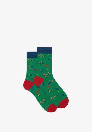 Green cotton socks featuring a blue ribbed cuff, red accents, and a playful pattern of tennis rackets and the text “See you in court.”