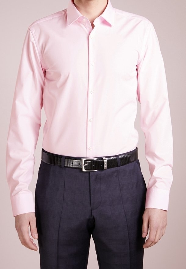 Lichtroze overhemd met een button-down kraag, lange mouwen en een gladde textuur, gecombineerd met donkergekraagde broeken en een zwarte riem.