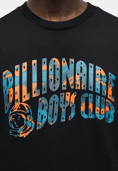 Μαύρο πουκάμισο με μεγάλο, καμπυλωτό κείμενο "Billionaire Boys Club" σε μπλε και πορτοκαλί σχέδια και ένα μικρό εικονίδιο κράνους αστροναύτη στα αριστερά.
