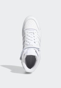 White leather sneaker with perforated toe box, flat laces, padded ankle collar, and grey accents. Textured outsole and branded insole visible.