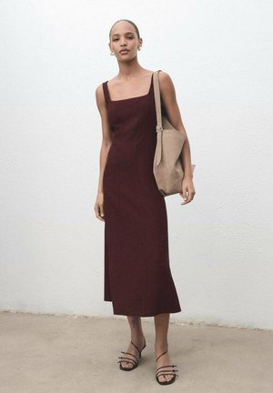 Robe midi bordeaux avec un décolleté carré et des fines bretelles. Associée à un sac tote beige et des sandales noires à lanières. Texture de tissu lisse.