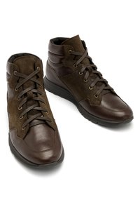 Brązowe skórzane i zamszowe półbuty za kostkę z zaokrąglonymi noskami, teksturowanym wierzchem, metalowymi oczkami i sznurowadłami. Wyściełana podeszwa zapewnia wsparcie.