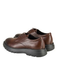 Bruine leren veterschoenen met een gestructureerde bovenkant, ronde neus en een stevige zwarte rubbere zool met een profiel.