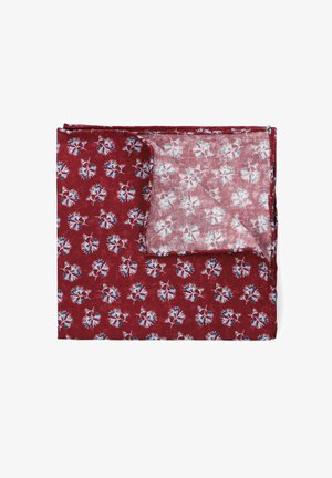 Czerwony materiał w wzory z małymi niebieskimi kwiatowymi designami. Lekki materiał o miękkiej teksturze. Złożony, z jednym rogiem lekko podniesionym.