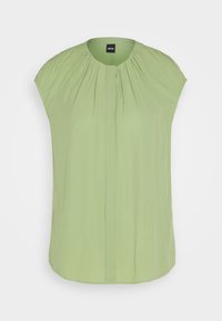 Blouse sans manches vert clair avec tissu froncé au niveau de l'encolure ronde et un pli vertical sur le devant, étiquette de la marque visible à l'intérieur du col.