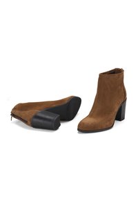 Bottes de cheville en daim marron avec un bout rond et un talon empilé. Fermeture à glissière sur le côté et semelle lisse. Détails texturés sur le talon.