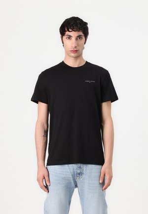 Camiseta de algodón negra con cuello redondo y mangas cortas, con un pequeño texto del logotipo en el pecho y un corte relajado.