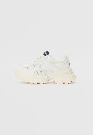 Maszywny biały sneaker z grubą podeszwą, panelami z siateczki i skóry, wzorzystymi sznurowadłami oraz czarnym napisem „Buffalo” na języku i boku.