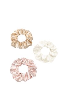 Tre scrunchies in satin: uno beige, uno rosa e uno bianco. Texture morbida con tessuto arricciato e nucleo elastico. Dettaglio del logo visibile.