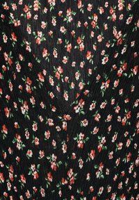Material negru cu un model texturat, având flori mici roșii și albe și frunze verzi, evidențiind un design floral pe un fundal întunecat.