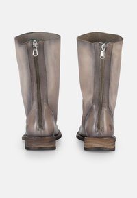 Botas de cuero gris hasta el tobillo con cremalleras distintivas, una suela de madera ligeramente desgastada y un acabado suave en la superficie superior.