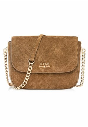 Brązowa torba na ramię zamszowa z przednią klapką, złotym łańcuszkowym paskiem i małym złotym logo marki umieszczonym na środku klapki.